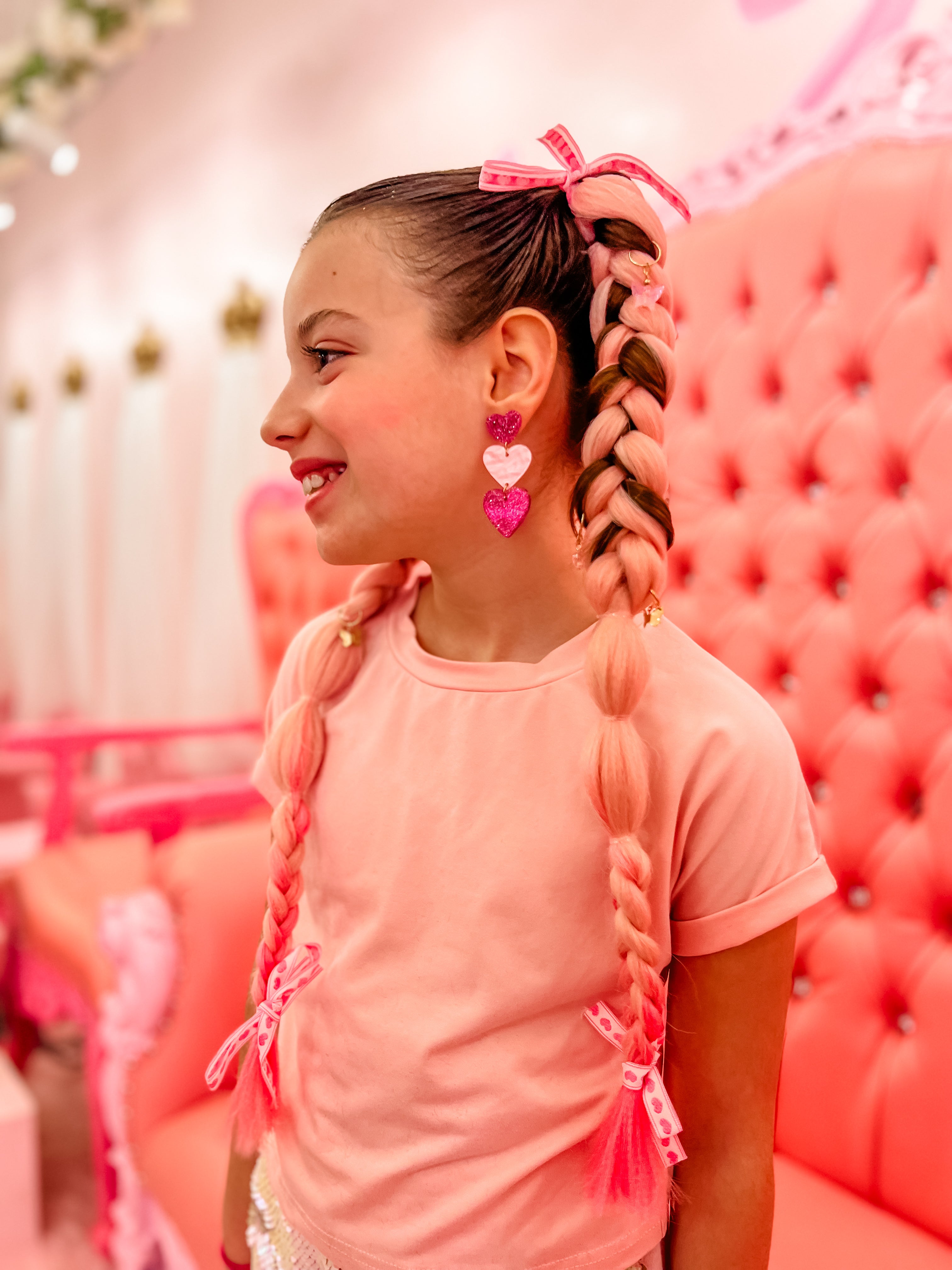 Excited girl receiving pink hair extensions for her hair